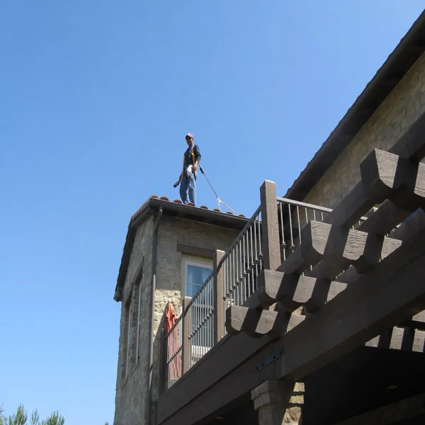 Worker at roof level using documented access and fall-protection equipment
