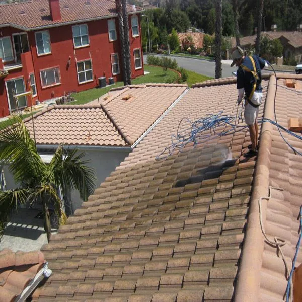 Roof cleaning technician cleaning a section of tile roof
