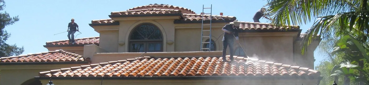 Technicians cleaning a multi-level tile roof on a Southern California home